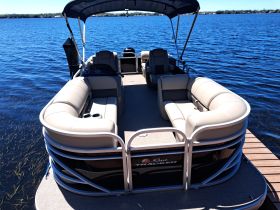 Interior view of a spacious pontoon boat featuring comfortable lounge seating, perfect for relaxing on the water.