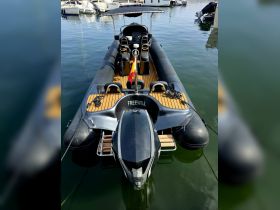 A sleek speedboat named 'FREEWILL' docked in calm waters, showcasing its stylish design and wooden deck — perfect for thrilling adventures on the water.