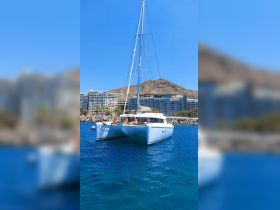 A group of friends relaxes on a catamaran, enjoying the sun and beautiful waters — perfect for a fun day out on the ocean.