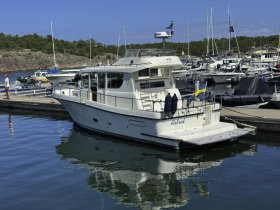 A beautiful yacht named 'Astrid' docked in a marina, showcasing its sleek design and reflection in the calm waters — perfect for leisurely outings or charters.