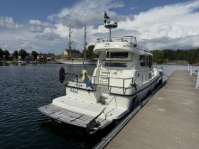 A beautiful view of the 'Astrid' yacht docked at the marina, surrounded by picturesque scenery and historical buildings.