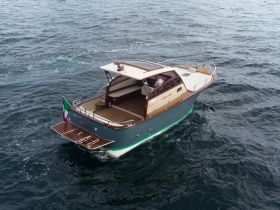A stunning aerial view of a classic yacht cruising through open waters, showcasing its elegant design and craftsmanship.