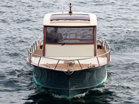 A stylish yacht is captured from the front as it glides through the water, showcasing its elegant design and craftsmanship.