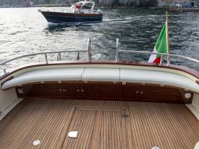 A beautifully crafted interior view of a boat's seating area, showcasing elegant wood finishes and a comfortable helm, perfect for relaxing while cruising.