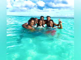 A joyful group of friends enjoys a fun day swimming in the crystal-clear waters, capturing the essence of a perfect tropical getaway.