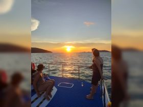 A group enjoys a stunning sunset aboard a boat, creating a perfect backdrop for memorable moments on the water.