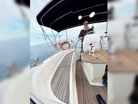 A man navigates the helm of a sailboat, showcasing the cozy interior and inviting atmosphere perfect for a day on the water.