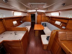 A cozy interior view of a yacht's cabin featuring comfortable seating and a well-equipped helm, perfect for relaxing during a sailing adventure.