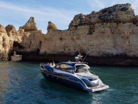 A sleek boat navigates through stunning coastal rock formations, showcasing the beauty of the landscape and the joy of on-water adventures.