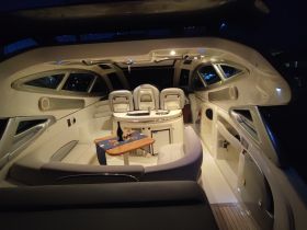 A cozy interior view of a boat's cabin featuring comfortable seating and a dining area, perfect for intimate gatherings or relaxing evenings on the water.