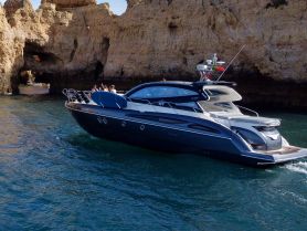 A sleek yacht navigates through stunning coastal caves, showcasing the beauty of the landscape and the joy of boating adventures.