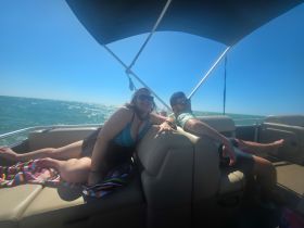 A group of friends relaxes on a boat under the sun, enjoying the beautiful ocean view — perfect for a day of leisure on the water.
