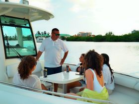 A group of friends enjoys drinks and conversation aboard a boat, creating a perfect atmosphere for relaxation and fun on the water.