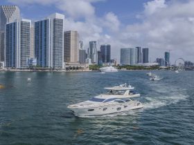 A stunning yacht navigates through the waters of a bustling city skyline, showcasing the perfect blend of urban and maritime beauty.