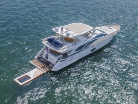 A stunning aerial view of a luxurious yacht cruising through sparkling waters, showcasing its elegant design and spacious deck.