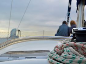 A couple enjoys a serene moment on a sailboat, creating the perfect backdrop for romantic sailing adventures.