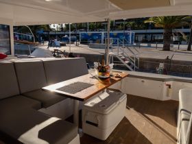A cozy interior view of a boat's dining area featuring comfortable seating and a table set for refreshments, perfect for relaxing moments on the water.