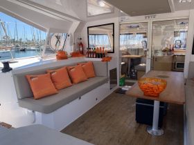 Interior view of a stylish boat lounge featuring comfortable seating and a well-stocked bar, perfect for relaxing and entertaining guests on the water.