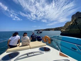 A group of friends enjoys a scenic boat ride, taking in the beautiful coastline and clear blue waters — perfect for a day of adventure on the sea.