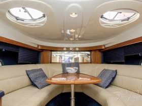A cozy interior view of a boat's lounge area featuring comfortable seating and elegant decor, perfect for relaxing on the water.