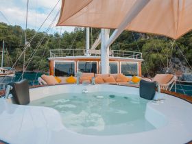 A luxurious jacuzzi on the deck of a boat, surrounded by comfortable seating, perfect for relaxation and enjoying the scenic views.