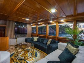 Luxurious interior of a boat cabin featuring elegant seating and modern amenities, perfect for relaxing while enjoying scenic views.
