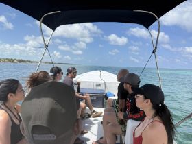 A group of friends enjoys a boat ride, taking in the scenic views of the water and coastline — perfect for a day of adventure on the sea.