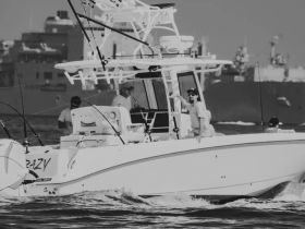 A group of anglers aboard a fishing boat, actively engaged in their pursuit on the water — a perfect scene for fishing enthusiasts.