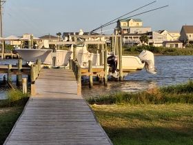 A fishing boat is docked at a pier, with a person preparing equipment for a day on the water. This scene captures the essence of boating adventures and fishing trips.