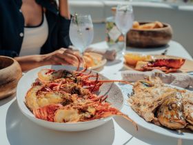 A delicious spread of seafood and cocktails is served on a boat, perfect for enjoying a luxurious dining experience on the water.