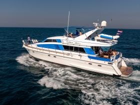 A luxurious yacht cruises through clear waters with guests enjoying the sun and scenery — perfect for unforgettable group outings on the water.