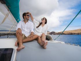 A couple enjoys a joyful moment aboard a boat, surrounded by stunning ocean views — perfect for romantic getaways or memorable adventures on the water.