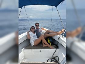 A happy couple relaxes on a boat, enjoying the ocean views and each other's company — perfect for romantic getaways or leisurely days on the water.