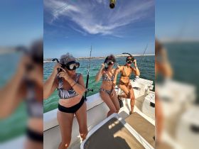 A group of friends prepares for a snorkeling adventure on a boat, showcasing excitement and camaraderie in the beautiful waters.