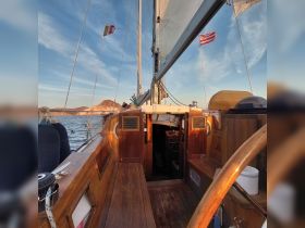 A beautifully crafted interior view of a sailing boat, showcasing the helm and wooden seating, perfect for a serene day on the water.