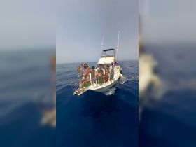 A lively group of friends waves from the deck of a boat, enjoying a fun day on the ocean — perfect for memorable outings and celebrations.