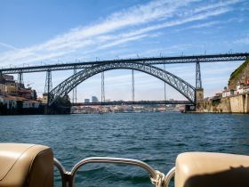 A stunning view of the iconic bridge spanning the river, showcasing the vibrant cityscape and clear blue skies — perfect for sightseeing tours.
