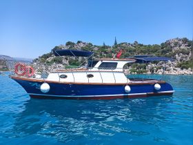 A beautiful side view of a yacht anchored in clear turquoise waters, showcasing its elegant design and serene surroundings.