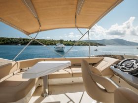 A stylish interior view of a boat's helm and seating area, showcasing a comfortable space for navigation and relaxation while enjoying scenic waters.