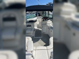 A spacious interior view of a boat's helm and seating area, showcasing comfortable seating and a well-equipped dashboard, perfect for a day on the water.