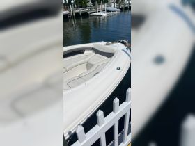 A close-up view of a sleek speedboat docked at the marina, showcasing its elegant design and comfortable seating.