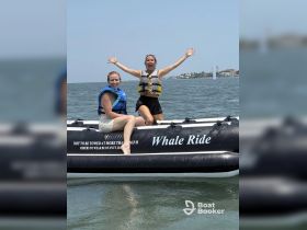 Two friends joyfully celebrate on a whale ride, showcasing the thrill of water activities — perfect for adventurous outings on the water.