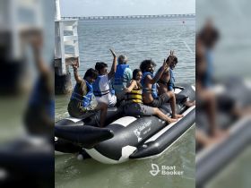 A lively group enjoys a fun outing on an inflatable boat, showcasing excitement and camaraderie on the water.