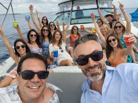 A lively group of friends celebrates aboard a yacht, raising their drinks in a toast — perfect for unforgettable party experiences on the water.