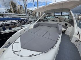 A spacious lounge area on a yacht, featuring comfortable seating and a sleek design, perfect for relaxing while enjoying the views at sea.