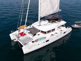 A stunning aerial view of the OOSEVEN catamaran sailing through calm waters, showcasing its spacious deck and elegant design, perfect for luxury charters.