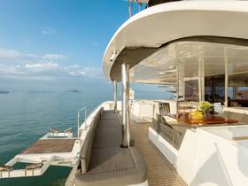 A beautifully designed interior of a yacht featuring comfortable seating and a dining area, perfect for relaxing and enjoying the scenic views while on the water.