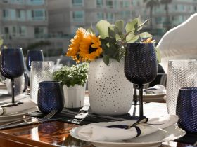 An elegant table setting featuring beautiful glassware and sunflowers, perfect for a sophisticated dining experience on a boat.