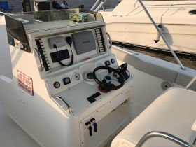 A detailed view of the helm and console area inside a boat, showcasing the navigation equipment and controls essential for a smooth sailing experience.