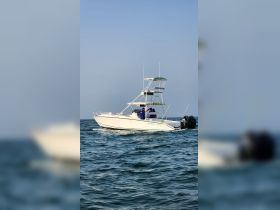 A Marlin 350 SF boat cruising through the water with crew members onboard, perfect for fishing adventures and exploring the open sea.